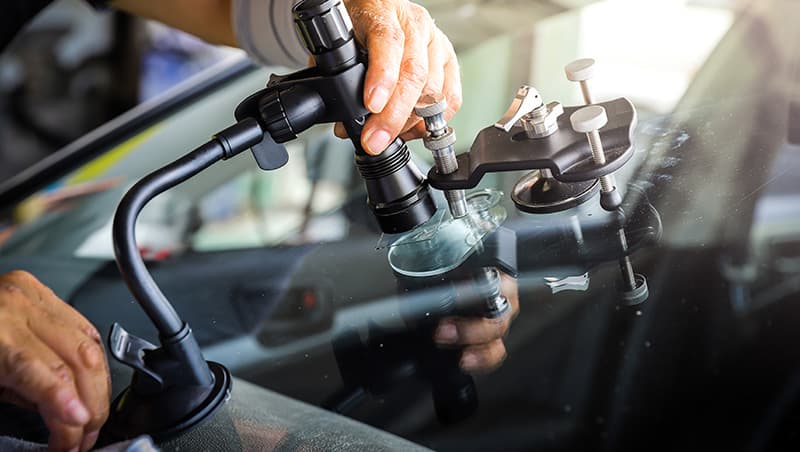 image of hand fixing glass of car